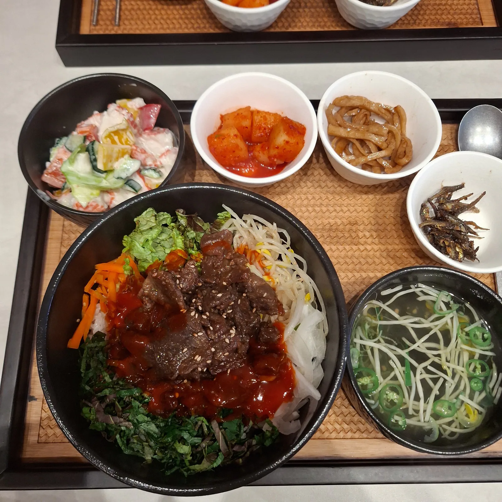 양념 불고기를 올린 불고기비빔밥과 국, 반찬